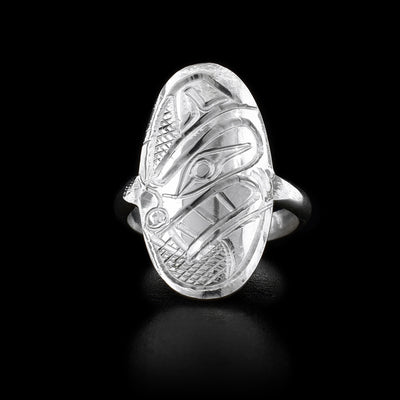 Sterling silver ring with curved oval “shield” on front that features side-view of a bear’s head with teeth showing. Cross-hatching background.