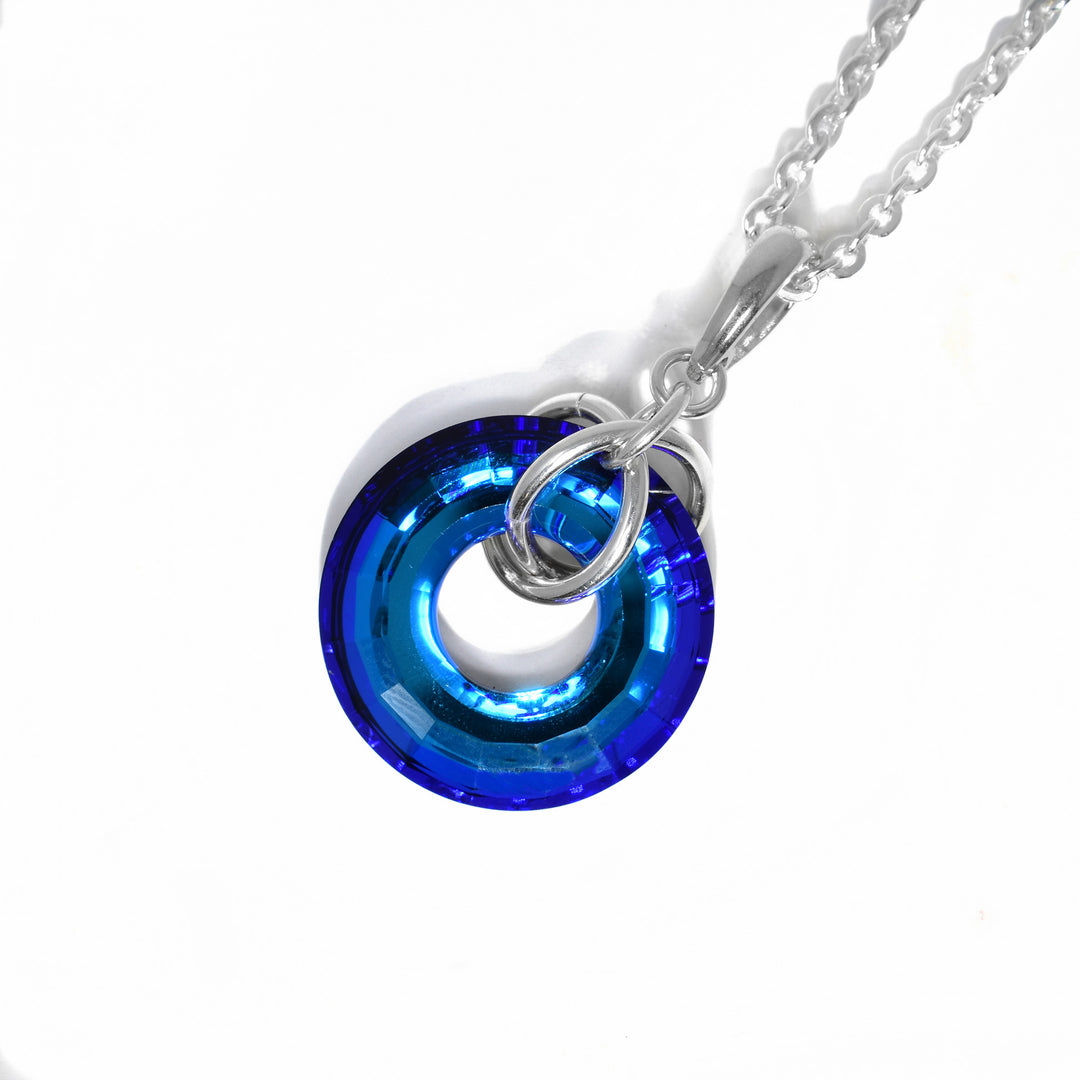 Round bermuda blue Swarovski crystal disc with sterling silver rings through the middle, attaching it to bail.