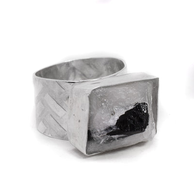 Sterling silver ring with wide, patterned band and raw horizontal rectangular clear quartz with black tourmaline. By Johanne Rousseau.