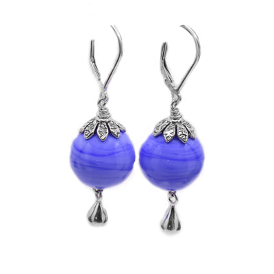 Sterling silver dangle earrings with silver teardrop shapes at bottom. They feature round periwinkle blue lampworked glass beads. Lever back hooks.