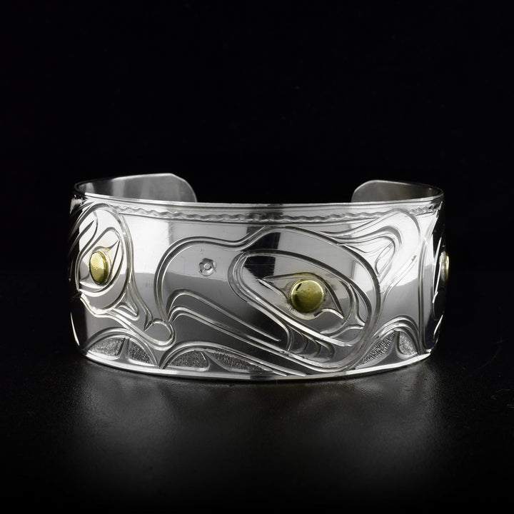 Sterling silver cuff bracelet featuring a thunderbird, raven, hummingbird and an eagle. Brass in eyes. By Kwakwaka’wakw artist Paddy Seaweed.