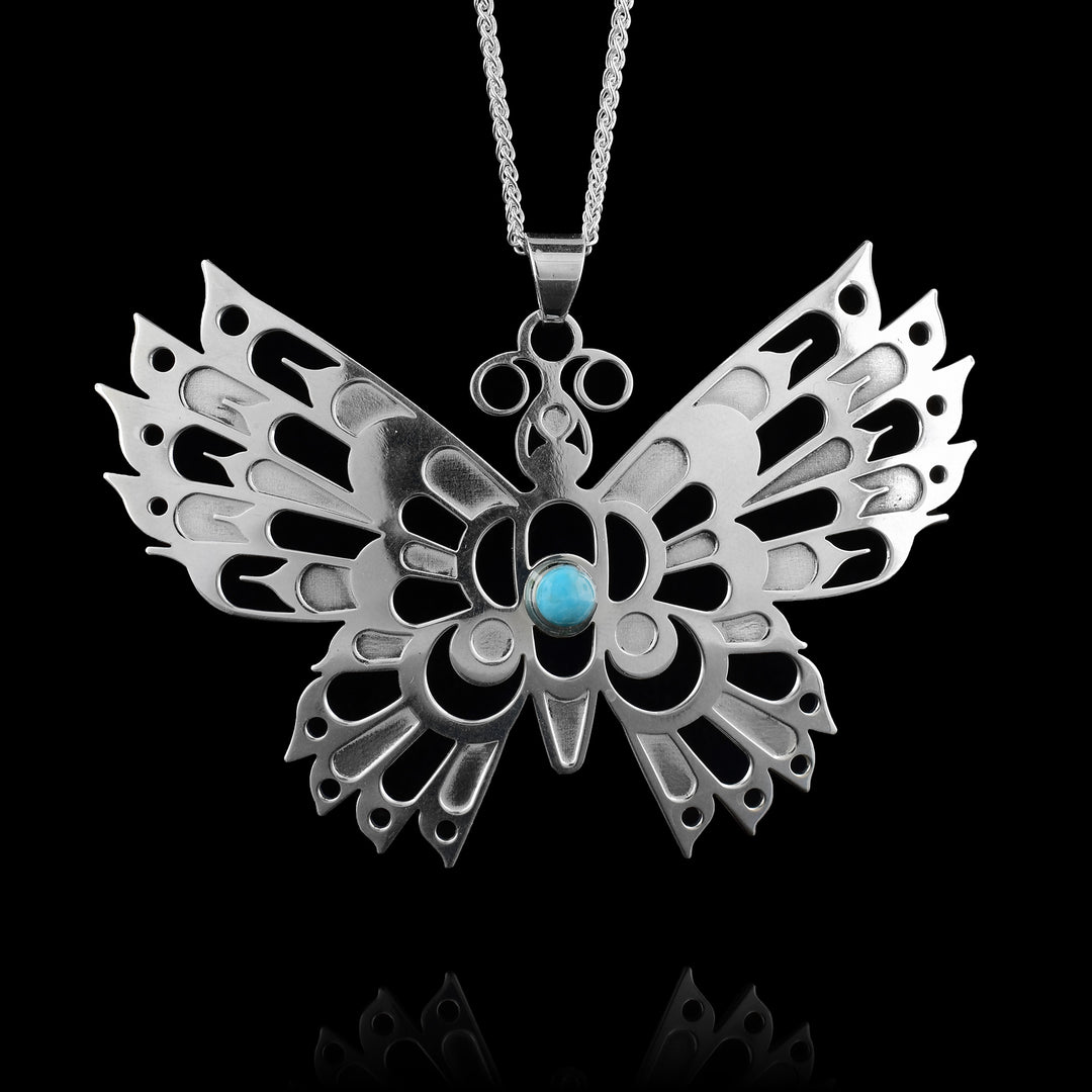 this large sterling silver Butterfly pendant by Haida Gwaii artist Gina Mae Schubert. Handcrafted and accented with a turquoise stone on the body.