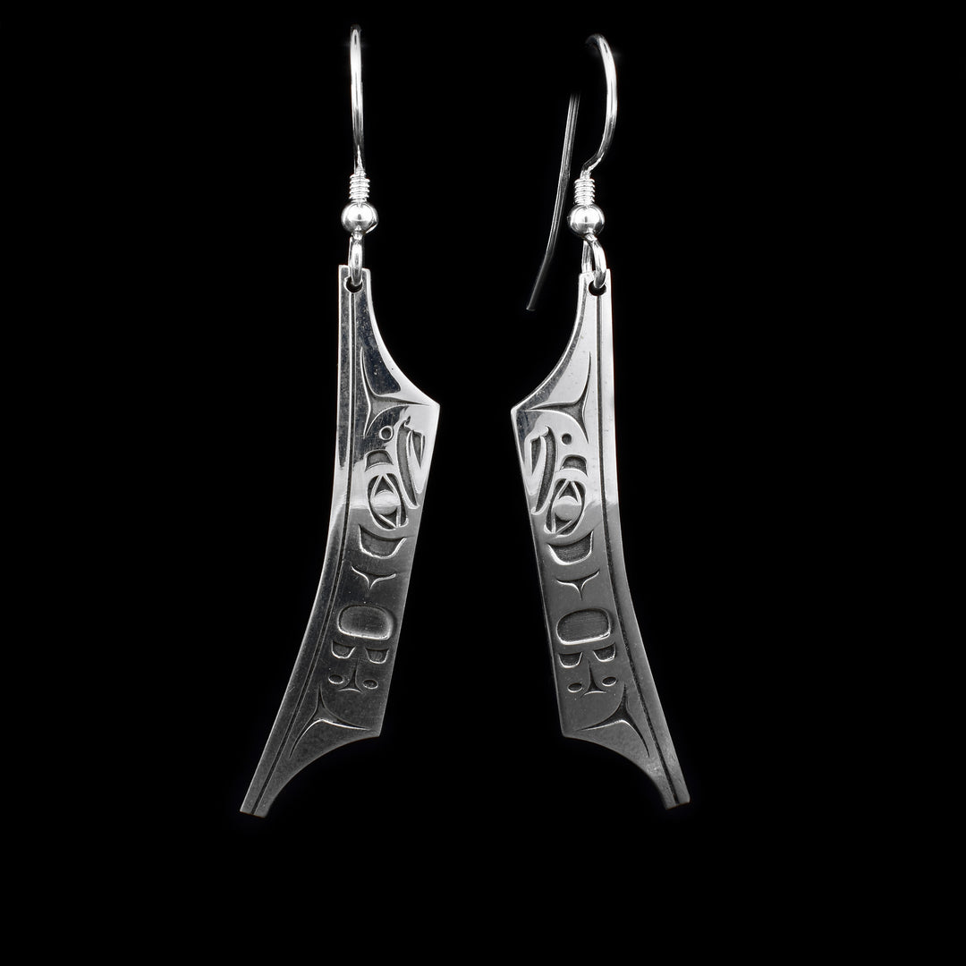 These sterling silver dangle earrings have hangs that are shaped like canoes. There are depictions of the Eagle carved into the hangs.
