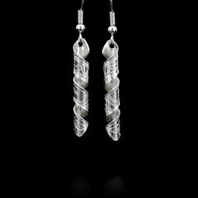 Both sterling silver earrings are a long rectangle, featuring an eagle, twisted into a spiral. By Coast Salish artist Gilbert Pat.