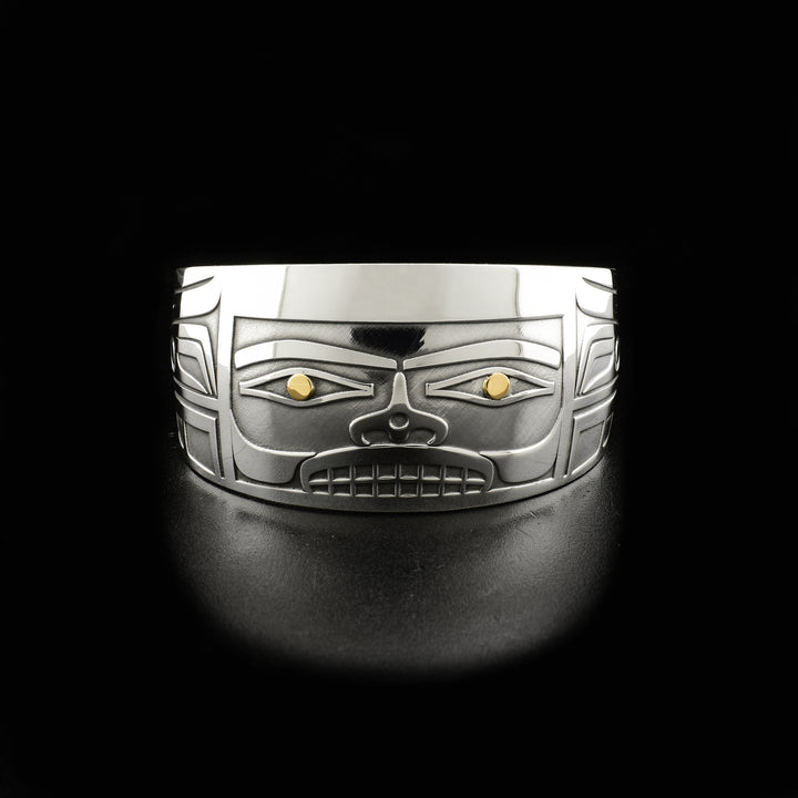 Sterling silver cuff bracelet with tapered ends. Front depicts rectangular 3D face, there is 18K gold in the eyes and design is meant to portray a Chilkat bentwood box.