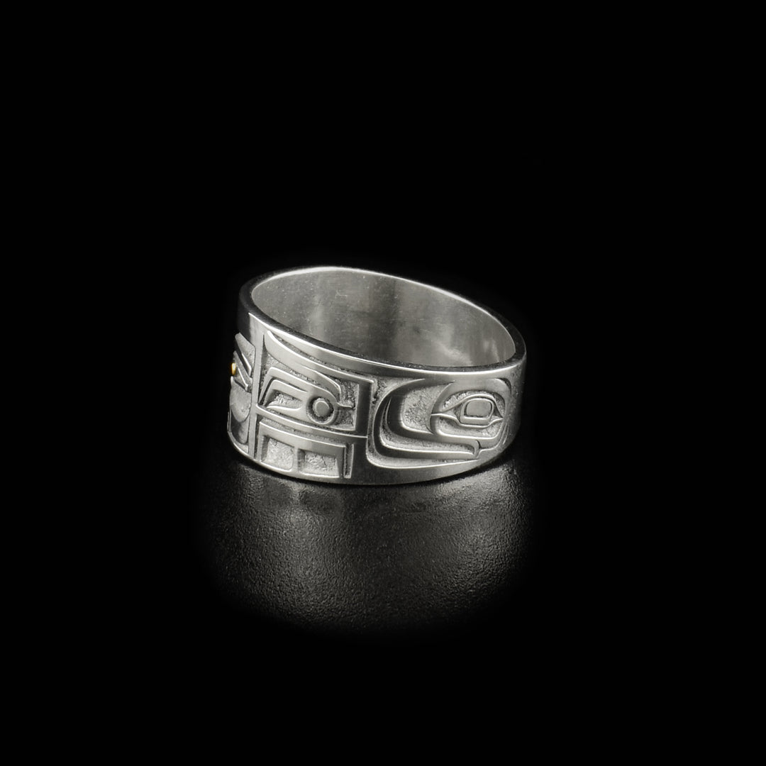 This 14k gold ring is designed to resemble Chilkat bentwood box. Front depicts a face. Pupils are made of 18K gold and rest of ring is sterling silver.