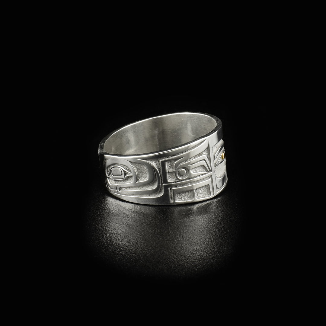 This 14K gold ring is designed to resemble Chilkat bentwood box. Front depicts a face. Pupils are made of 18K gold and rest of ring is sterling silver.