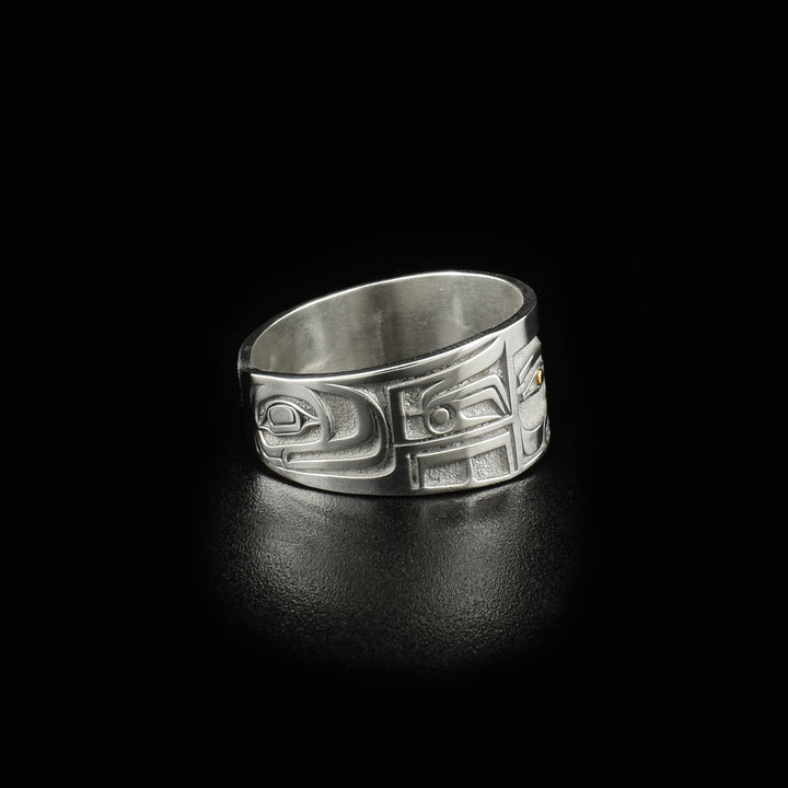 This 14K gold ring is designed to resemble Chilkat bentwood box. Front depicts a face. Pupils are made of 18K gold and rest of ring is sterling silver.
