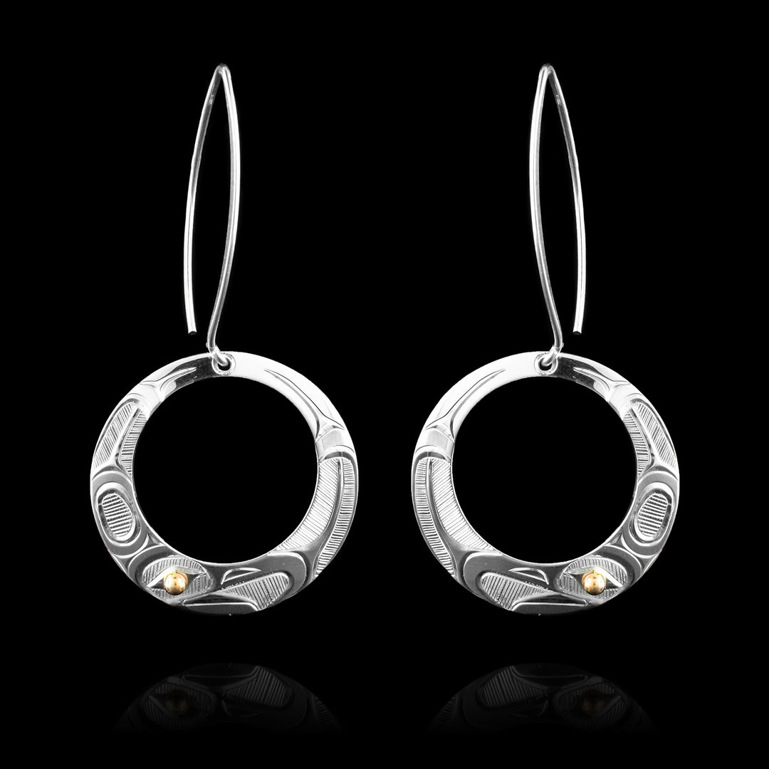 These open circle eagle dangle earrings are made with sterling silver and hand carved with the legend of the eagle around the faces of the earrings. Using 14k gold for the Eagles eye.