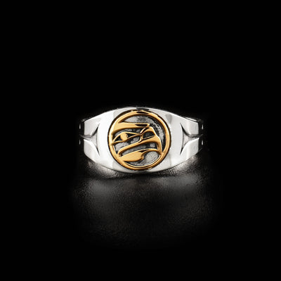 Sterling silver signet ring with 14K gold design on front. Front depicts the side-view of an eagle head facing left. Identical, minimalist design on sides.