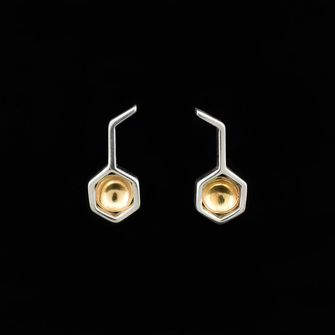 Sterling silver bar, bent at top, drops down with hexagon at bottom. Hexagon has a concaved, round piece of 14K gold inside.