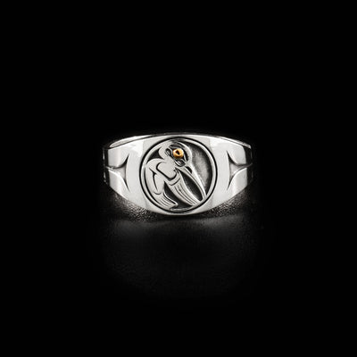 Sterling silver signet ring with hummingbird on front. Side-view of hummingbird facing left with wing out. Bird has 14K gold in the eye. Identical, minimalist design on sides.