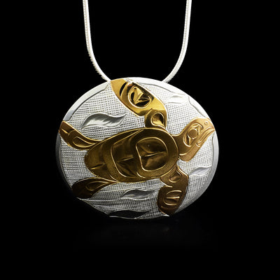 14K gold plated swimming turtle with design made up of lines and ovoids. Rest of round pendant is sterling silver, seaweed on cross-hatching.
