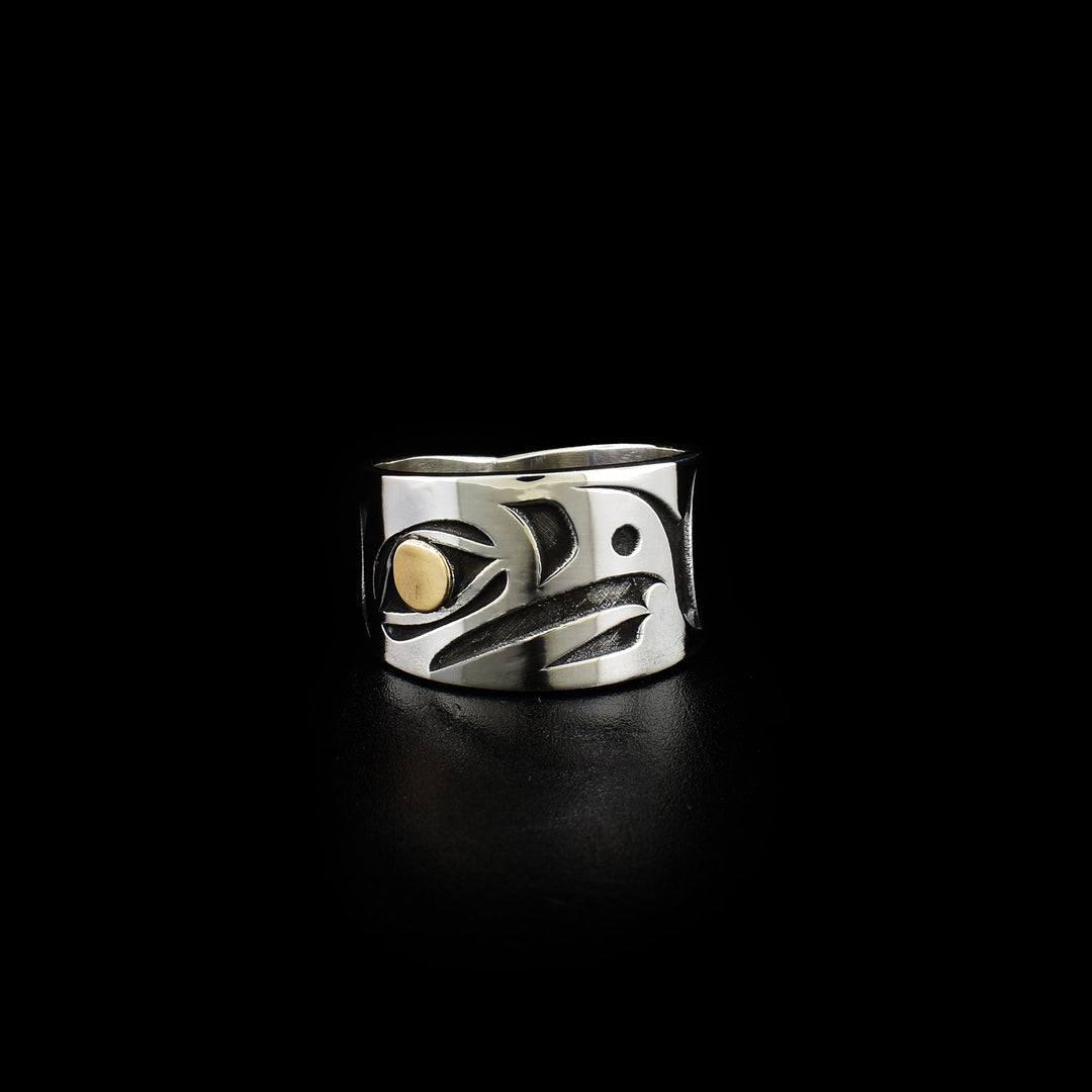 This Eagle ring depicts a side-view of the Eagle head facing left with 14K gold in eye. Design has been cast into the band. Background is oxidized, emphasizing three-dimensional design.