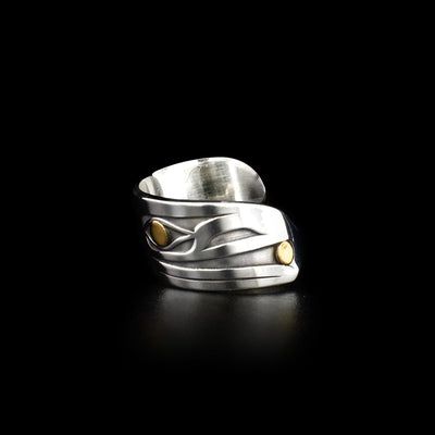 Sterling silver laser-carved ring. Band wraps around once. Design depicts side-view of raven’s head facing left. 18K yellow gold ball in beak and gold in eye. Oxidized background emphasizes three-dimensional design.