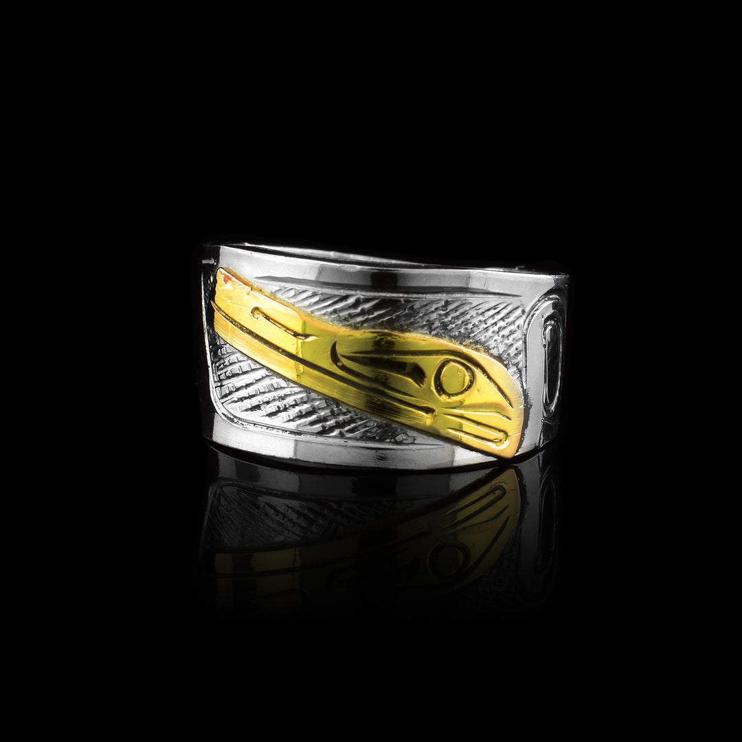 Graham Henry wrap band made from sterling silver and 10k gold. It features a hand-carved Raven legend in gold against a silver band with traditional markings.