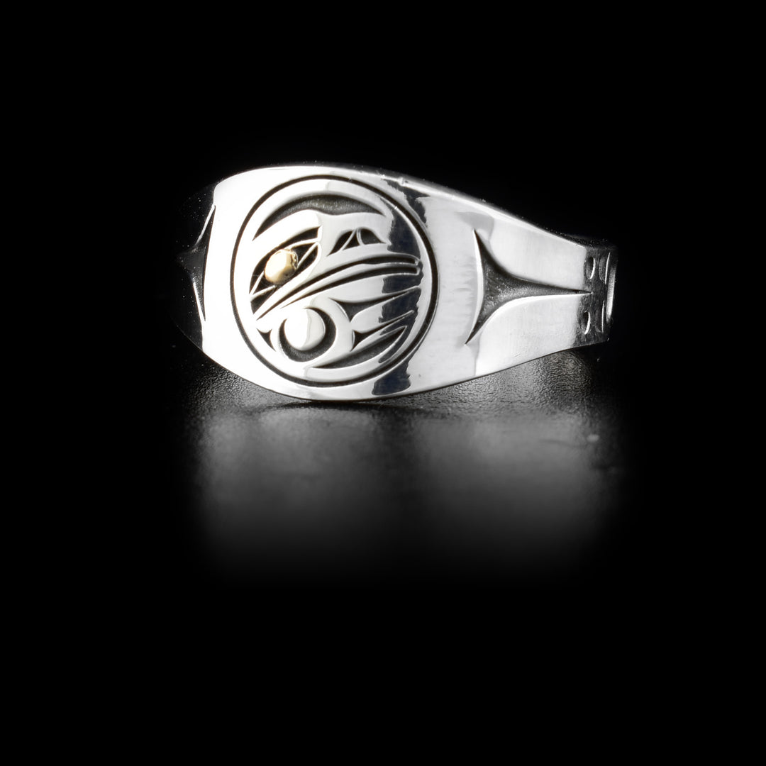 This sterling silver and 14K gold Raven signet ring has a depiction of the Raven cutout from the surface of the signet. The eyes of the Raven are made from 14K gold.