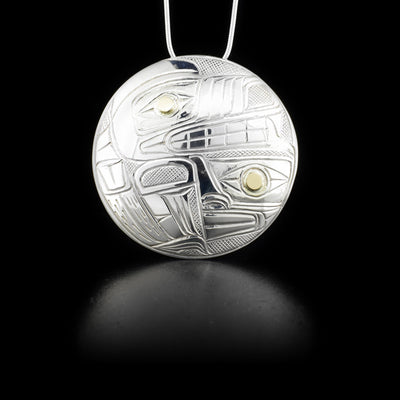 Pendant depicts wolf in front of moon. 14K yellow gold in eye of moon and wolf. By Heiltsuk artist Reg Gladstone.