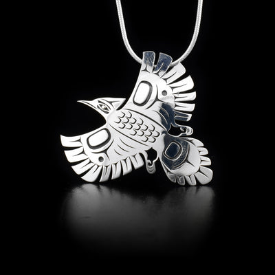 Sterling silver pendant of Steller’s jay in flight with laser-carved designs. 18K yellow gold in eye. Hidden bail on back. By Tahltan artist Grant Pauls.