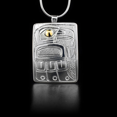 Sterling silver rectangular pendant featuring thunderbird with 14K yellow gold in eye. Cross-hatching background. By Heiltsuk artist Reg Gladstone.