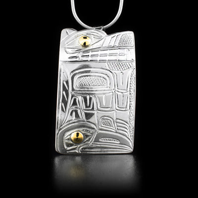 Sterling silver pendant featuring wolf and raven. 14K yellow gold in the eyes. By Heiltsuk artist Reg Gladstone.