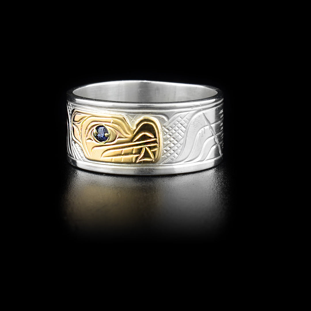 3/8” wide sterling silver ring with 14K yellow gold wolf face on front. Blue sapphire in eye. By Kwakwaka’wakw artist Victoria Harper.