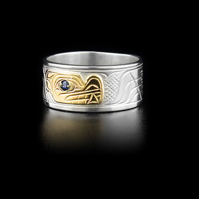 3/8” wide sterling silver ring with 14K yellow gold wolf face on front. Blue sapphire in eye. By Kwakwaka’wakw artist Victoria Harper.