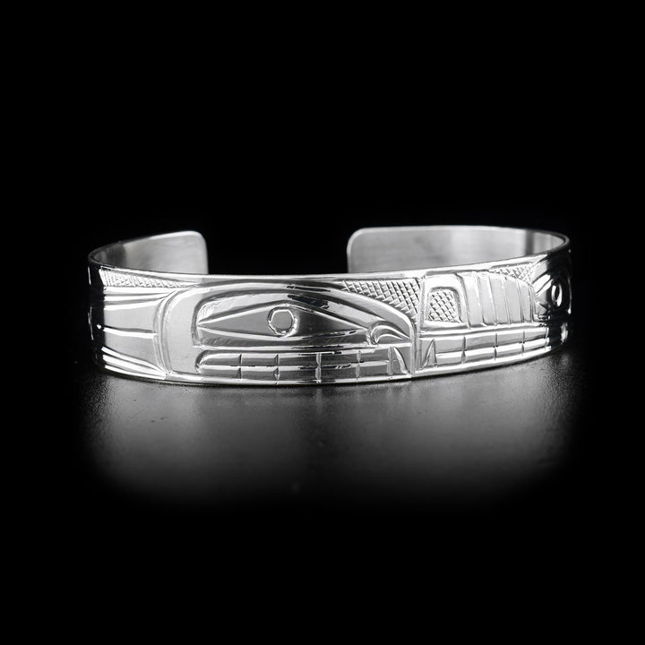 This Orca and Wolf bracelet cuff depicts orca and wolf snout to snout. Orca on right side. Cross-hatching background. Hand-carved by Heiltsuk artist Reg Gladstone.
