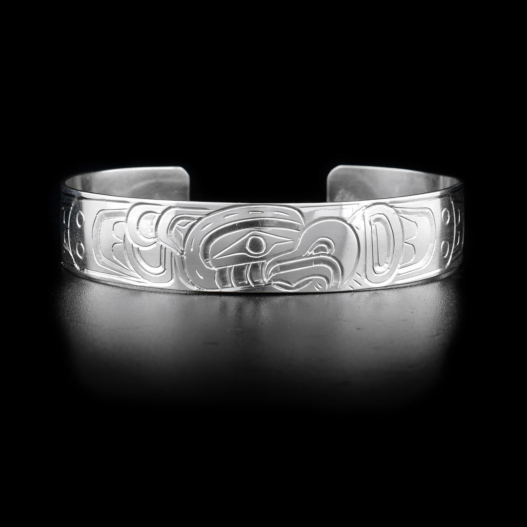This Thunderbird bracelet has a single, sterling silver band with a gap in the back. There is a depiction of the Thunderbird carved into the surface of the band.