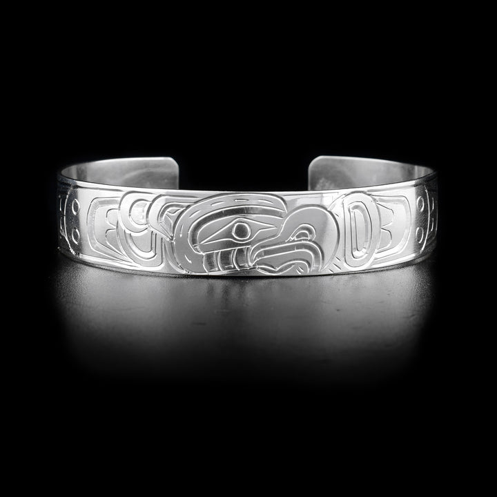 This Thunderbird bracelet has a single, sterling silver band with a gap in the back. There is a depiction of the Thunderbird carved into the surface of the band.