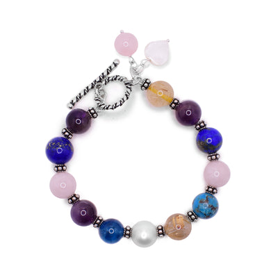 Multi gemstone beaded bracelet with sterling silver. Bracelet closes with a toggle clasp at end and contains lapis lazuli, pearl, rutilated quartz, amethyst, rose quartz, turquoise and kyanite.