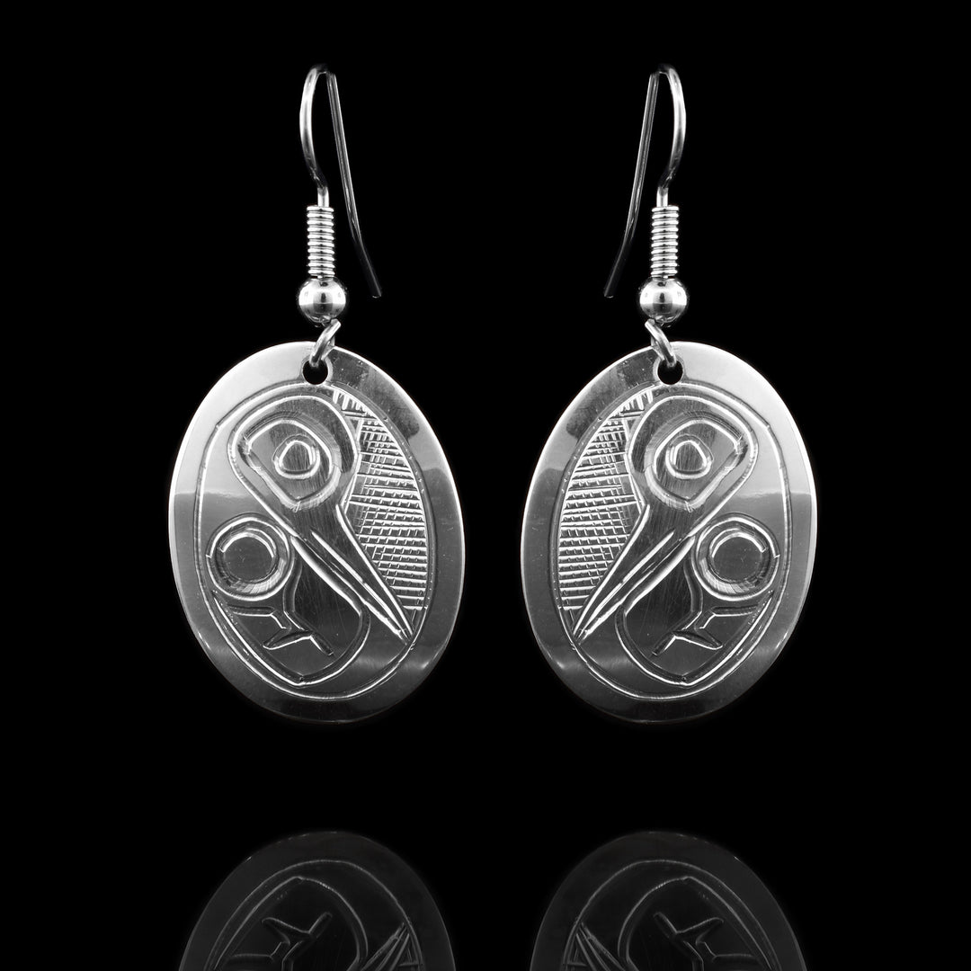 These sterling Silver Oval Hummingbird Earrings are handcarved with he hummingbirds head and wing angled down with a cross hatch background.