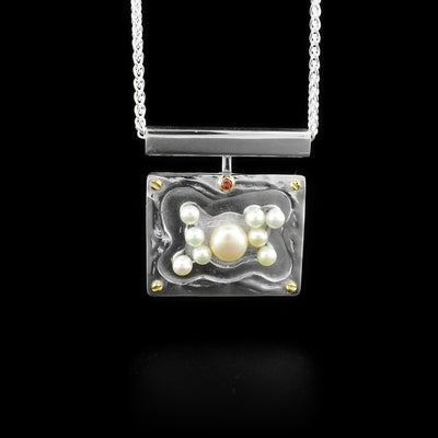 Sterling silver horizontal rectangle pearl pond pendant. Features a cluster of white freshwater pearls, dainty 14K yellow gold bolt adornments in the four corners and a garnet set in 14K yellow gold in the top-center. Abstract design.