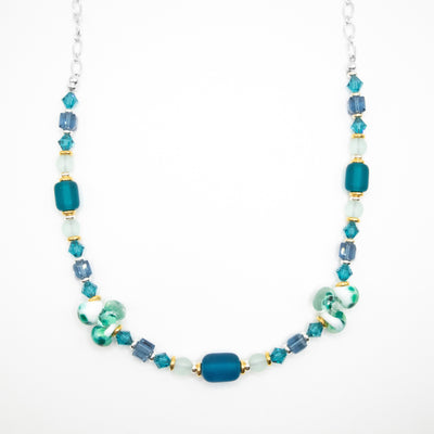 Sterling silver chain necklace featuring beads of Swarovski crystal and glass along the front. Colours are mainly shades of blue and green.