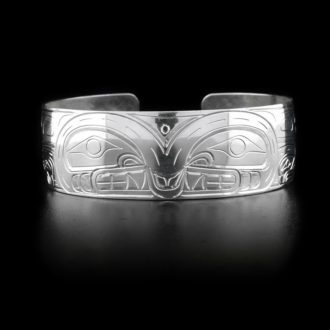This Orca bracelet has a wide band made from sterling silver and has a gap in the back. There are beautiful depictions of the Orca carved into the band. The legends are depicted facing each other.