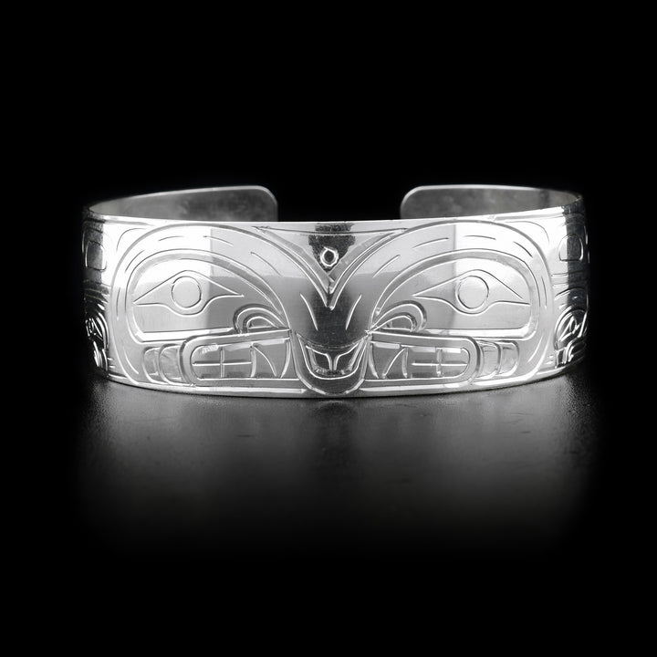 This Orca bracelet has a wide band made from sterling silver and has a gap in the back. There are beautiful depictions of the Orca carved into the band. The legends are depicted facing each other.