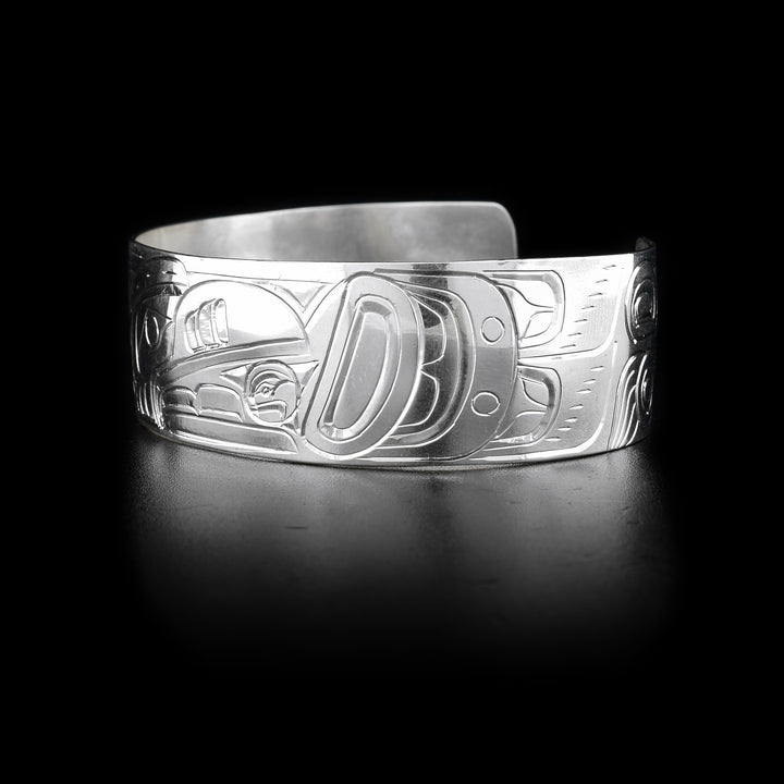 Bracelet with raven head, sun in beak, facing left on front and body on sides. Hand-carved by Kwakwaka’wakw artist William Cook.