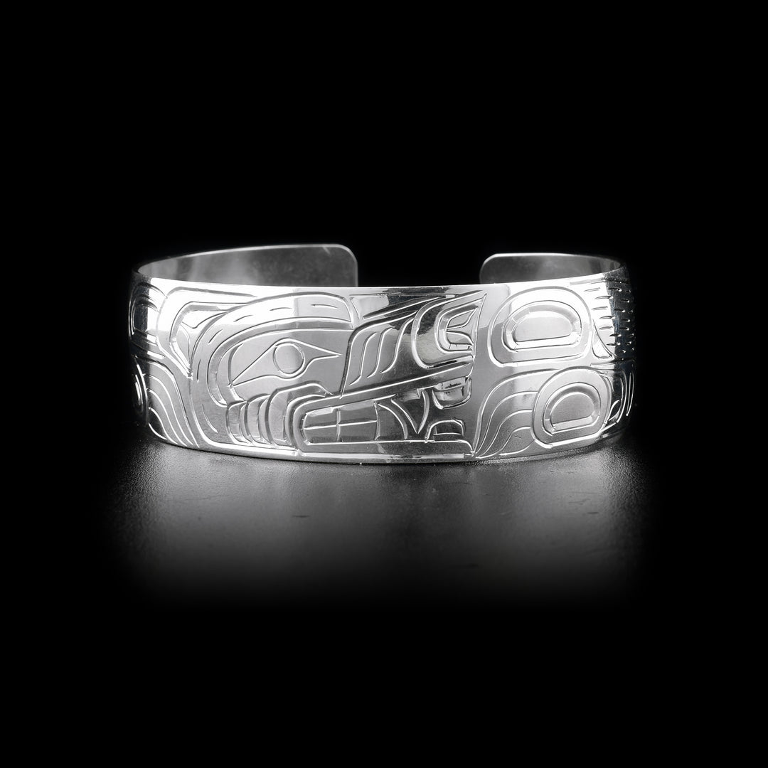 This Wolf bracelet has a single, wide and sterling silver band with a gap in the back. There is a depiction of the Wolf carved into the surface of the band.