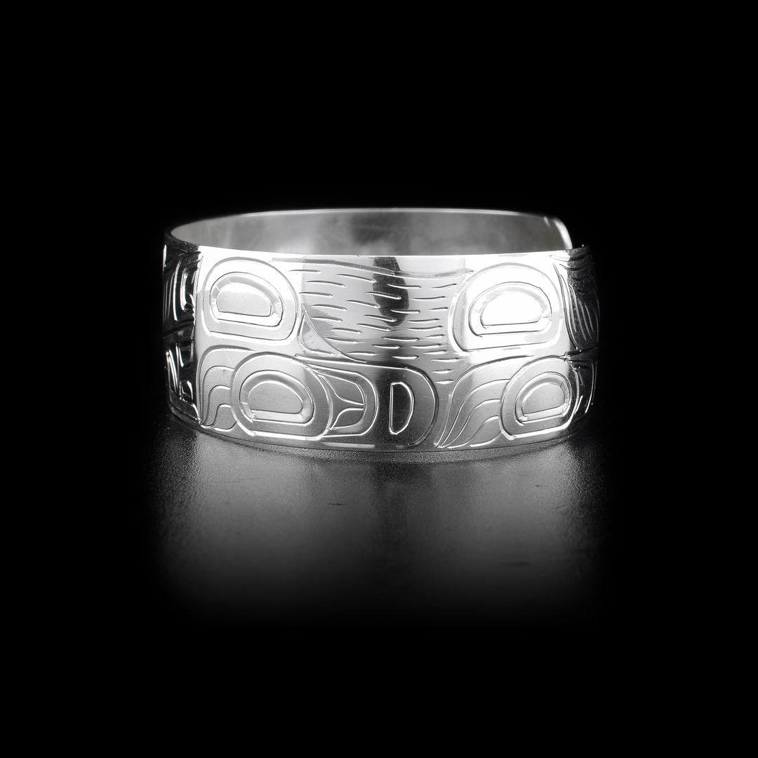 Bracelet with wolf head facing left on front and body on sides. Hand-carved by Kwakwaka’wakw artist William Cook.
