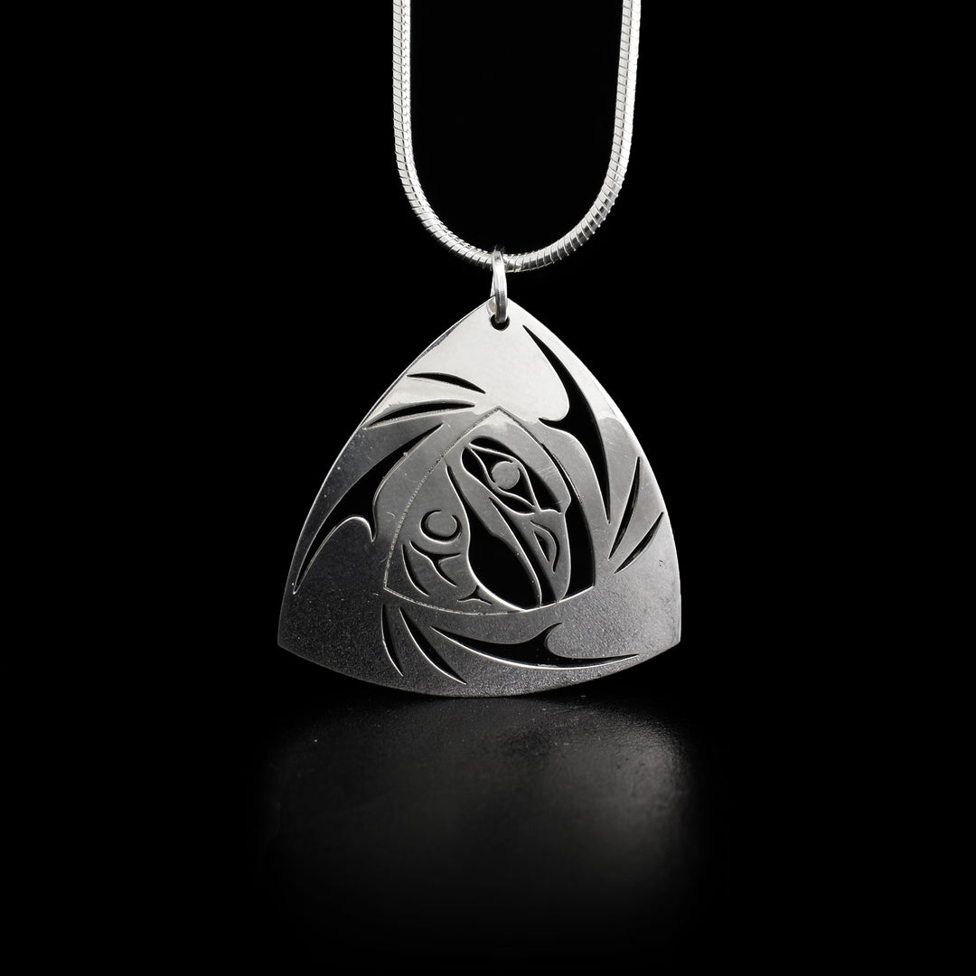 This raven pendant is a triangular shape with the side-view of a raven's head in the center facing the right. It's wing is underneath. Parts of the pendant have been cut out.