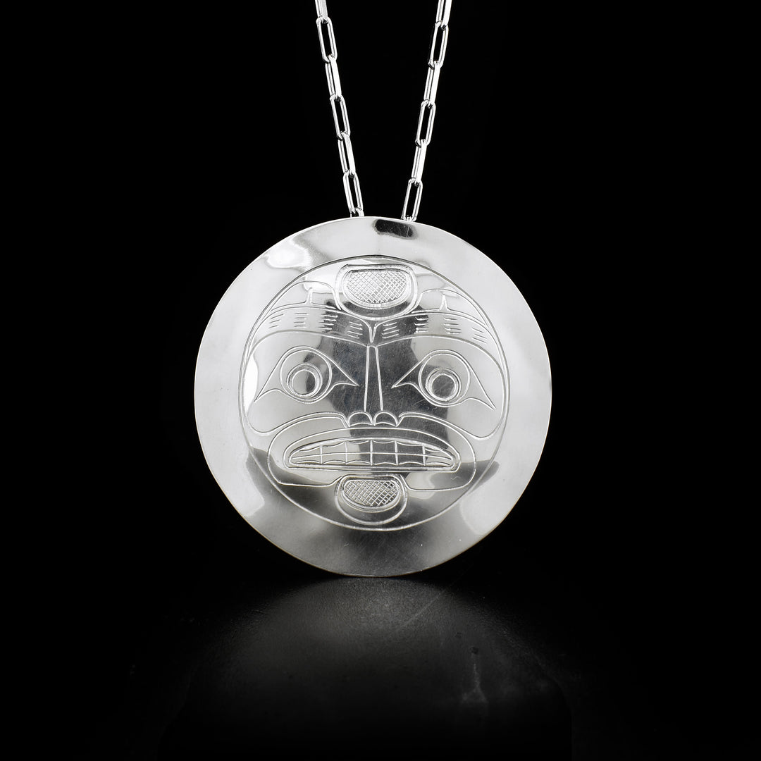 This sterling silver moon pendant is large and circle shaped. There are carvings on the surface of the pendant that depicts the Moon in full position.