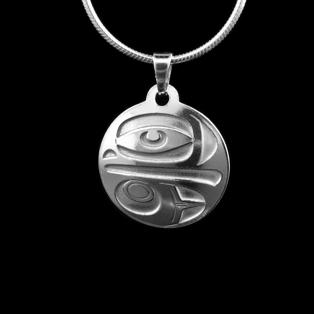 This Eagle silver pendant has a circle shape and is made from sterling silver. There are depictions of the eagle cast into the pendant with eyes, beak, and wing. 