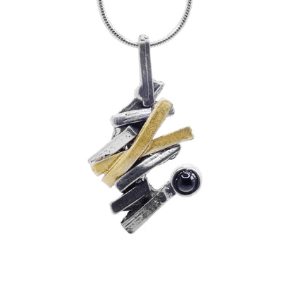 This abstract black onyx pendant is made from several gold plated and pewter strips that are connected to make a jagged appearance. The piece drops down and has a round, black onyx gem at the bottom of it.