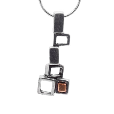 This abstract pewter pendant is made up of several, cutout and pewter squares. The squares are stacked at different angles and drop down before making a small cluster at the bottom. There is black glass in the center of the most bottom square.