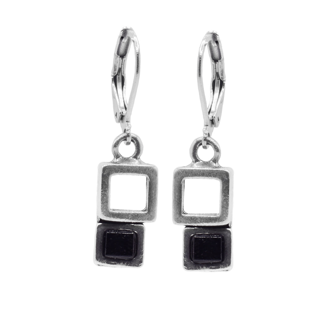 These black glass earrings have cutout squares made from pewter with cubes made of black glass attached to the bottom of the pewter. The hangs dangle from stainless steel hooks.