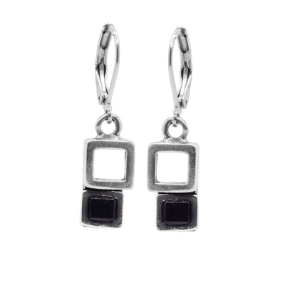 These black glass earrings have cutout squares made from pewter with cubes made of black glass attached to the bottom of the pewter. The hangs dangle from stainless steel hooks.