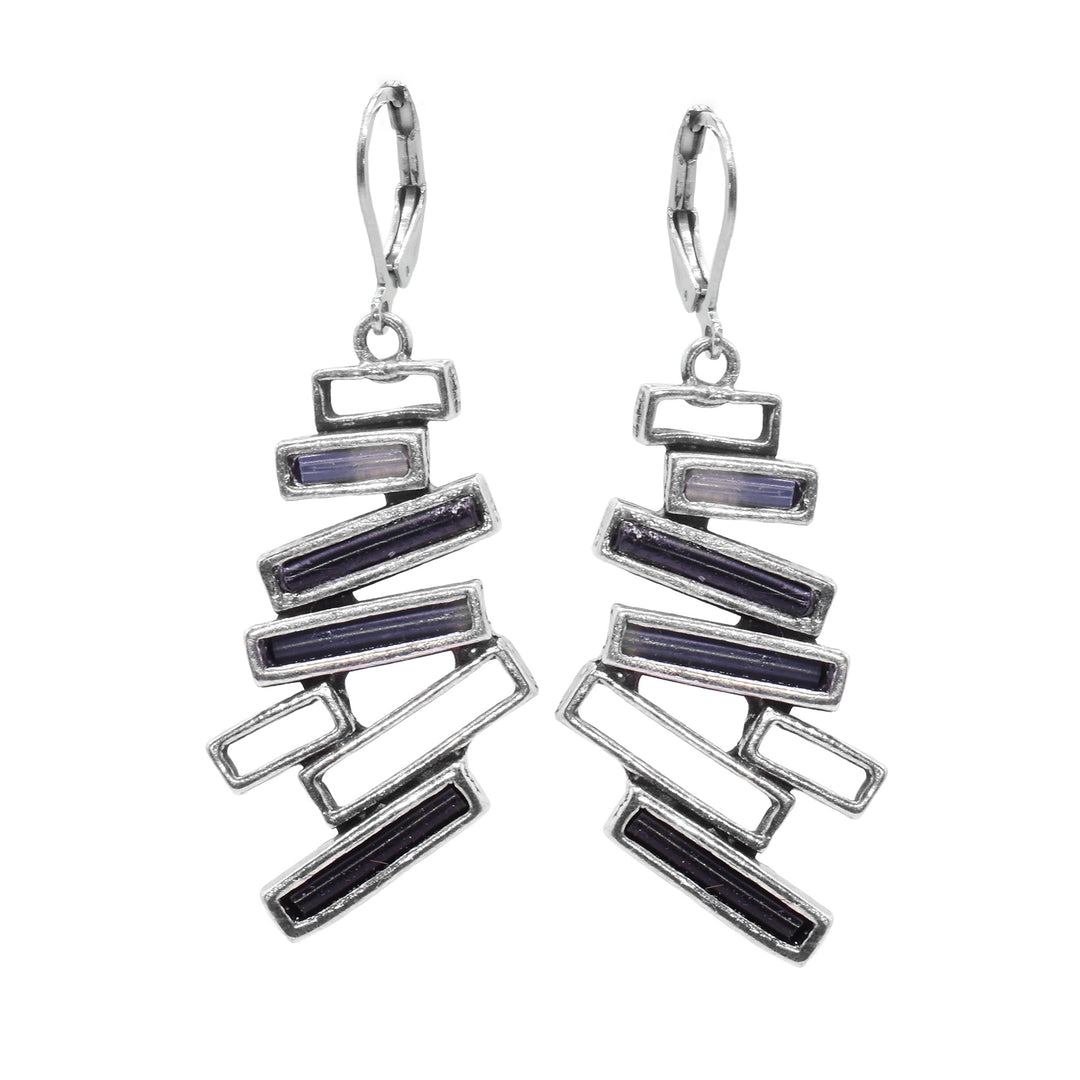 These pewter, abstract earrings have large hangs that are made up of several thin, cutout and pewter rectangles that are stacked horizontally at different angles. Three of the rectangles on each hang are filled with black and grey molten glass.