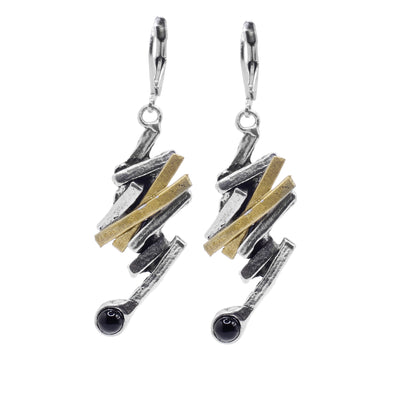 These black onyx and gold earrings are made from thin, pewter rectangles that connect to each other at different angles and drop down. There are two band of gold plated material on each piece and at the bottom of the hangs are round, black onyx gemstones.