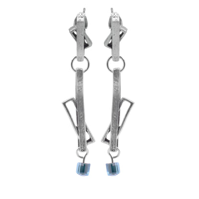 These glass drop earrings have multiple cutout, pewter rectangles that are connected with a small link. Some of the rectangles link through the other to form abstract shapes. The earrings are long and made of two separate dangling pieces and there are turquoise glass cubes attached to the bottom.