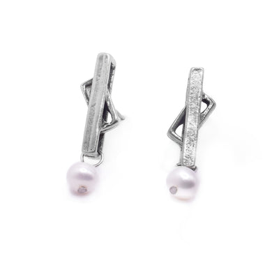 These drop stud earrings consist of a cutout rectangle with a small rectangle held between the larger rectangle. The rectangles are made from pewter and at the bottom of these stud earrings are freshwater pearls.